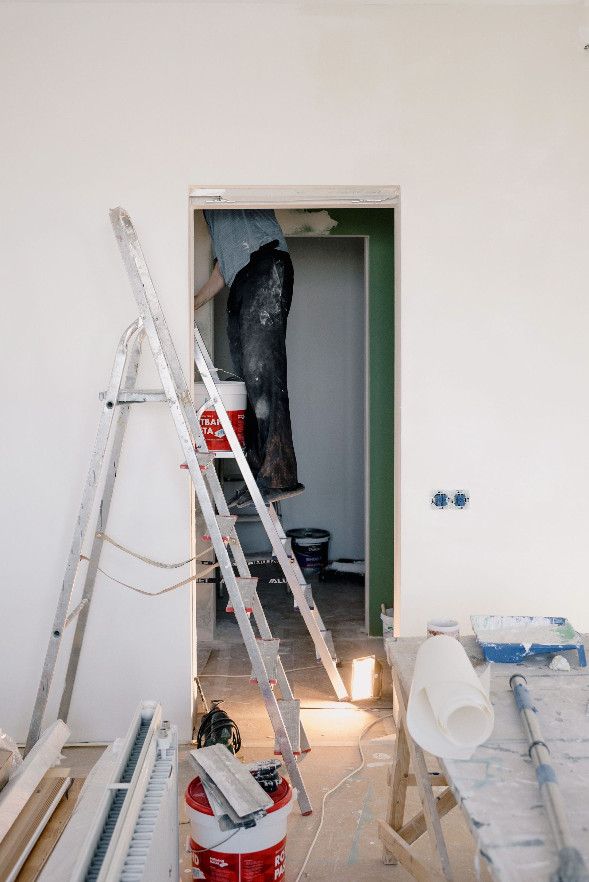 Crop unrecognizable male in dirty clothes working in room during renovation works at home